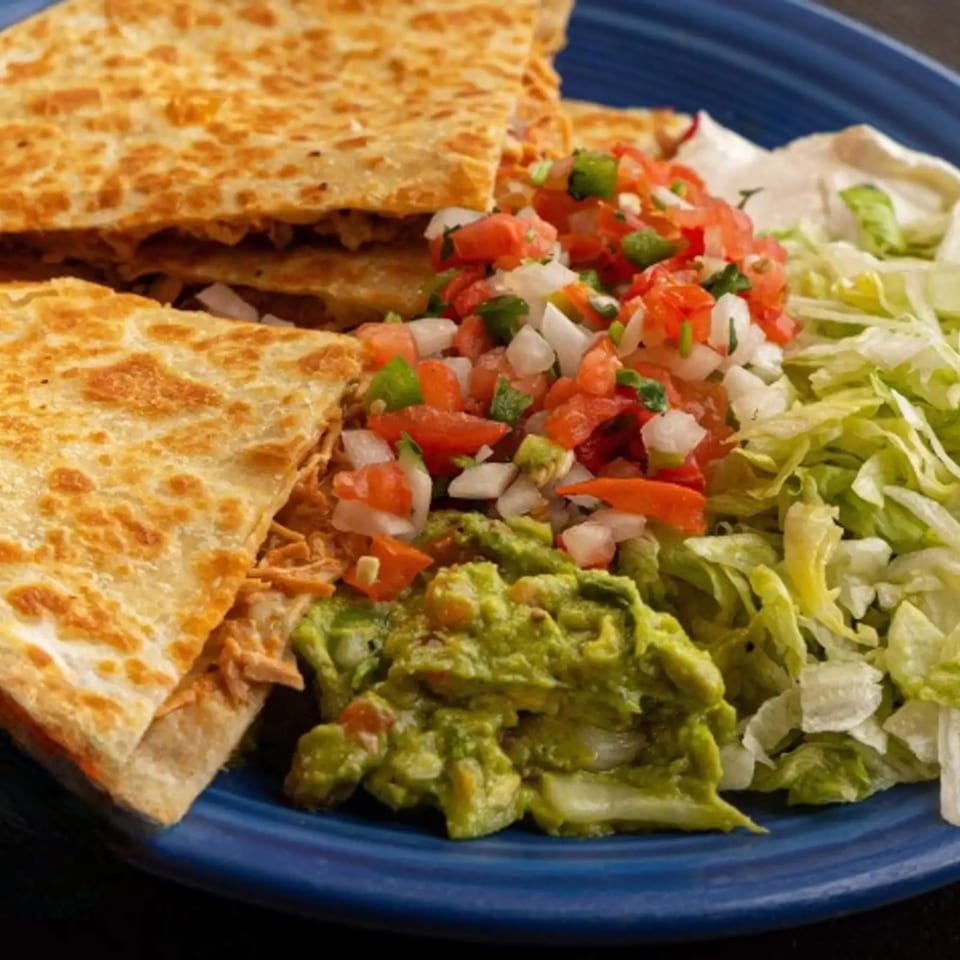Dos Charros chicken quesadillas with guacamole, pico de gallo, shredded lettuce, and sour cream.